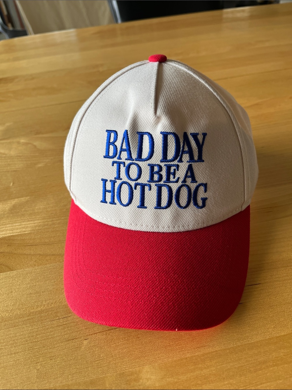 Cream and Red Baseball Cap with Blue 'Bad Day To Be A Hot Dog' Embroidery